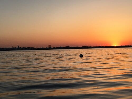 Sunset over Lake Monona as viewed from Monona, Wisconsin's Stone Bridge Park. The City of Madison's skyline can be seen across the waters of Lake Monona