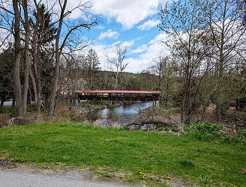Photo of a pedestrian covered bridge over South Branch Tunkhannock Creek at Christy Mathewson Park in Factoryville , Pennsylvania . Photo taken from Thompson Road looking east.