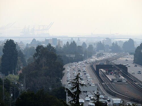 Rockridge station viewed from a nearby hill in August 2018, with Port of Oakland cranes visible through the fog
