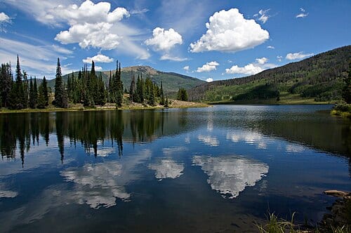 In this scene, afternoon clouds reflect from Pearl Lake's deep blue waters. Steamboat and Pearl Lakes State Parks are located in Clark County near the north west quadrant of Colorado just south of Wyoming.