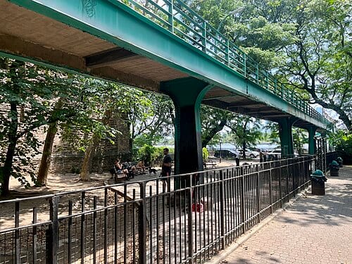 Dog run and pedestrian overpass at Peter Detmold Park in Manhattan, New York